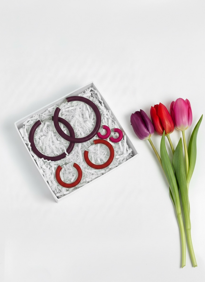 Mother's Day Gift Set featuring the "Classic Clay Hoop Earrings", buy two get a free pair, in a box with tulips on a pink background.