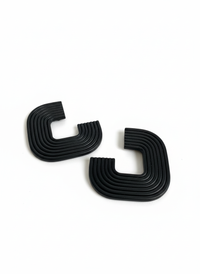 A pair of black 'Gia' statement earrings on a white surface, handmade by Sunni Dineen.