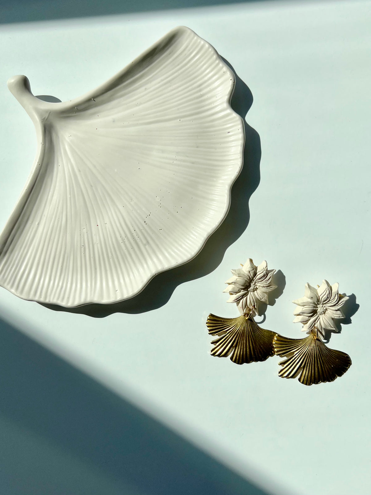 Pair of 'Yasmine Statement Earrings' on a white surface paired with the 'Ginkgo Leaf Trinket Dish', handmade by Sunni Dineen.