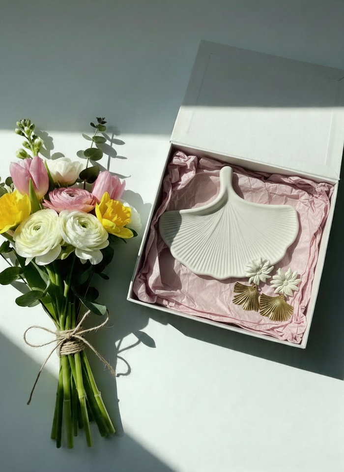 Ginkgo Leaf Mother's Day Gift Set showcased including the bone 'Ginkgo Leaf Trinket Dish' and cream 'Yasmine Earrings' next to a bouquet of flowers.