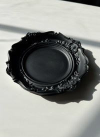 The black Resin Baroque Trinket Dish resting on a white surface, handmade by Sunni Dineen.