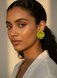 Model wearing handmade oversized statement stud earrings in limeade created by Sunni Dineen Handcrafted Design—jewelry for women who wear their story.