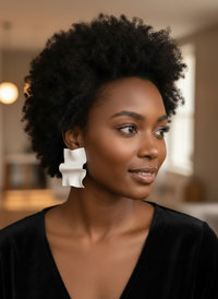 Model wearing wavy handmade lightweight statement stud earrings in white—jewelry created by Sunni Dineen Handcrafted Design for women who wear their story.