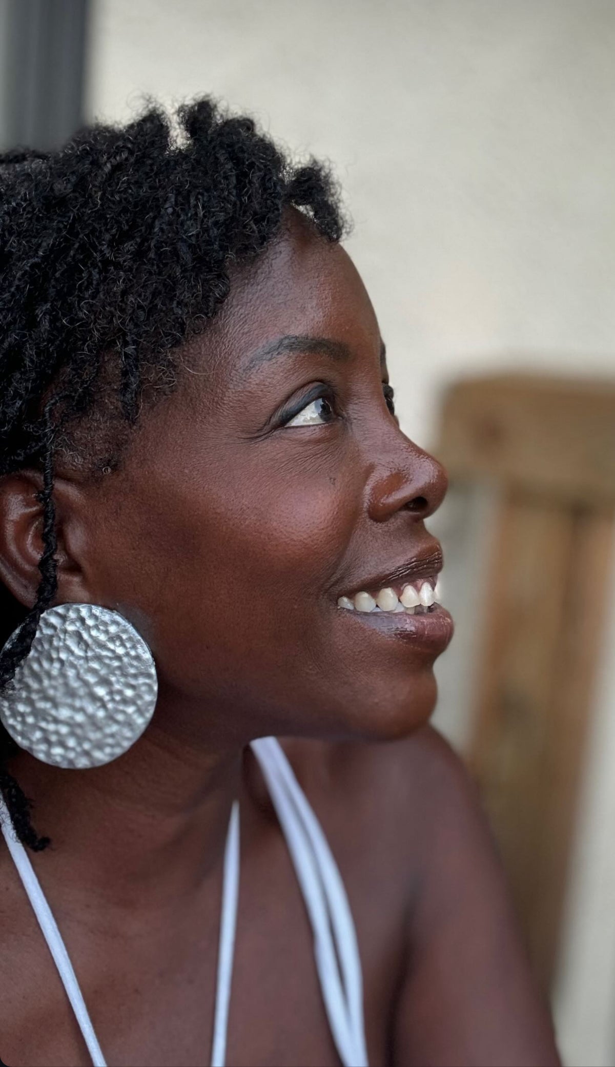 Model wearing oversized handmade hammered stud statement earrings in silver created by Sunni Dineen Handcrafted Design—jewelry for women who wear their story.