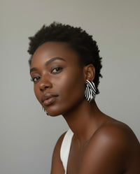 A woman styled wearing zebra "Monae" sculptural statement earrings 