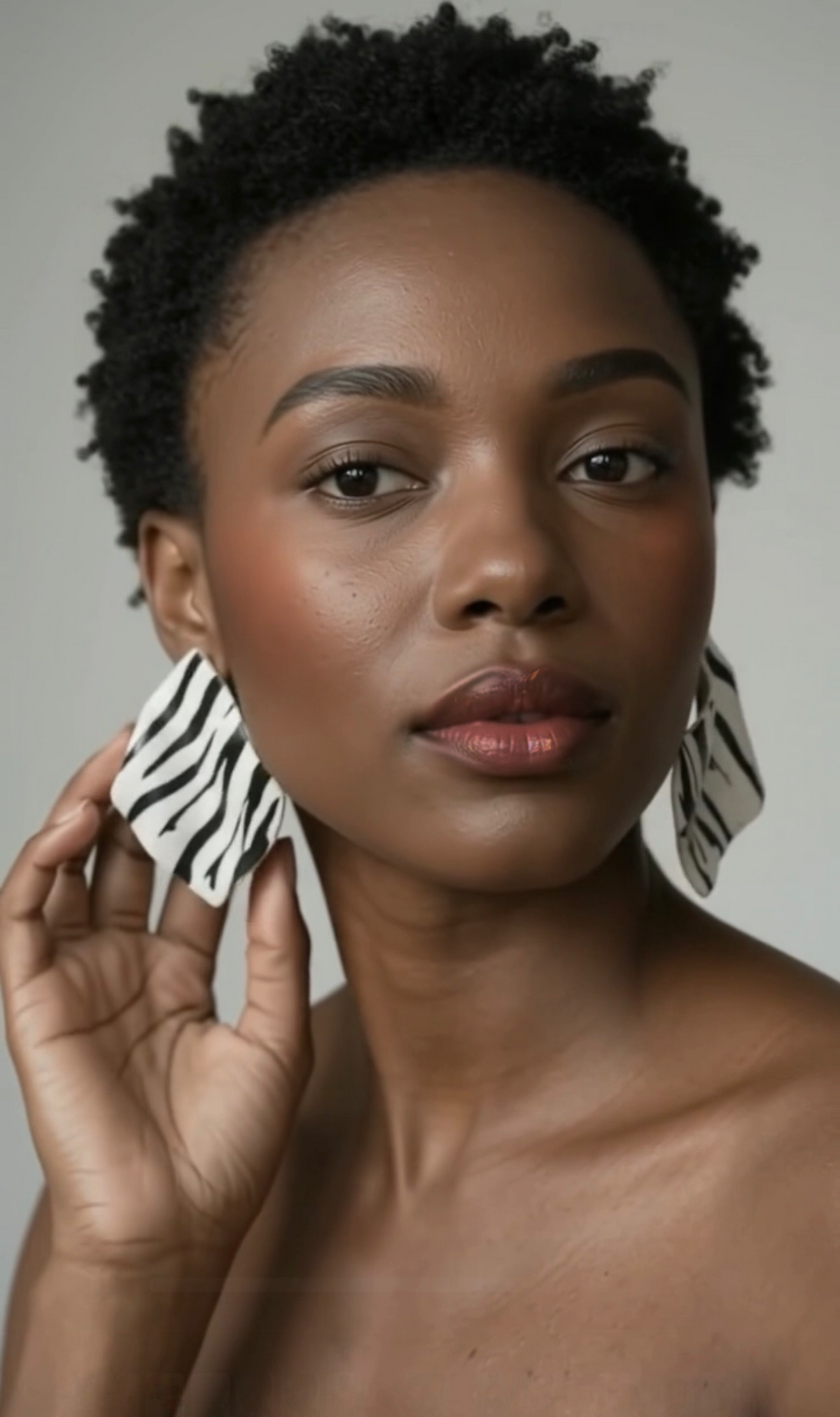 A woman styled wearing zebra "Monae" sculptural statement earrings 