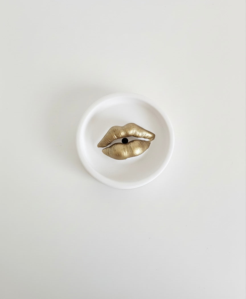 An ivory Sculptural Lips Incense Holder with gold lips, handmade by Sunni Dineen, displayed on a white surface.