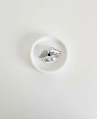 An ivory Sculptural Lips Incense Holder with silver lips, handmade by Sunni Dineen, displayed on a white surface.