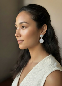 Model wearing a cream linen vest and a pair of silver leaf seashell bauble earrings handmade by Sunni Dineen.