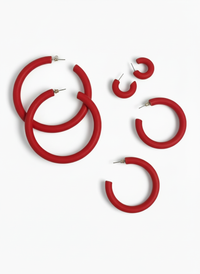 Pairs of different sized red "Classic Clay Hoop Earrings" handmade by Sunni on a white background.